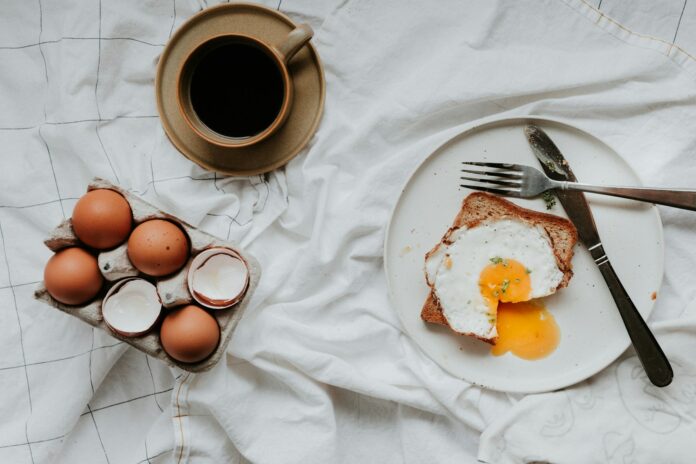 Photo by Priscilla Du Preez 🇨🇦 egg on white ceramic plate beside stainless steel fork and knife