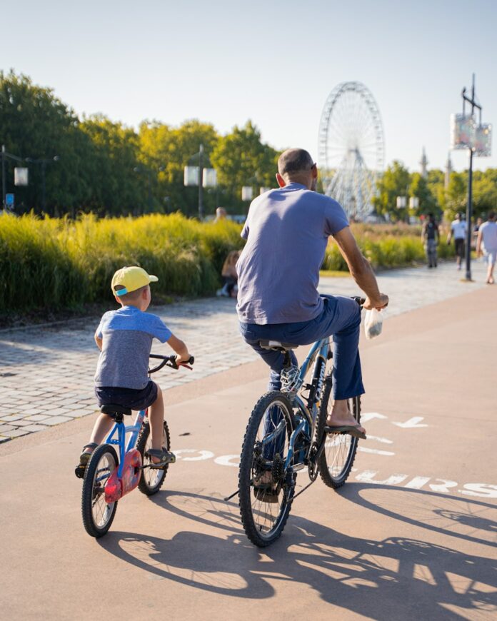 Photo by Anthony Persegol man in blue t-shirt riding on black bicycle during daytime