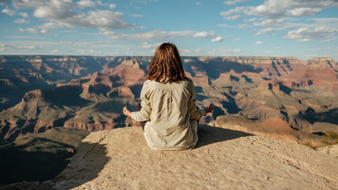 Photo by Matteo Di Iorio woman sitting on hill