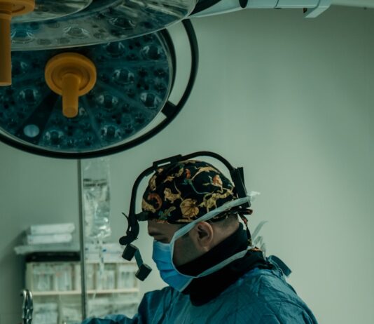 AI 기반 건강 관리, 미래형 의료 혁신의 중심에 서다 a man in a surgical gown is operating a machine